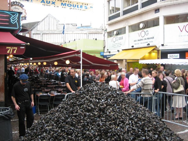 Le tas de moules grandit et beaucoup de gens attendent pour en manger encore ! Un week-end de braderie à Lille. Braderie de Lille le dimanche matin.