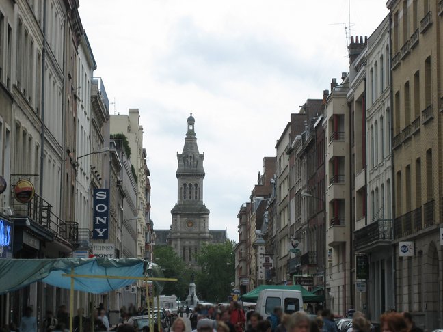 Rue Nicolas Leblanc depuis la place de la République, l'église Saint-Michel au bout. Un week-end de braderie à Lille. Braderie de Lille le samedi après-midi.